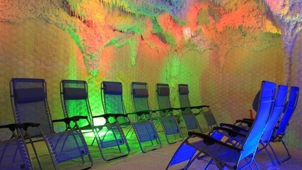 A room with rows of blue lounge chairs and a colorful wall.