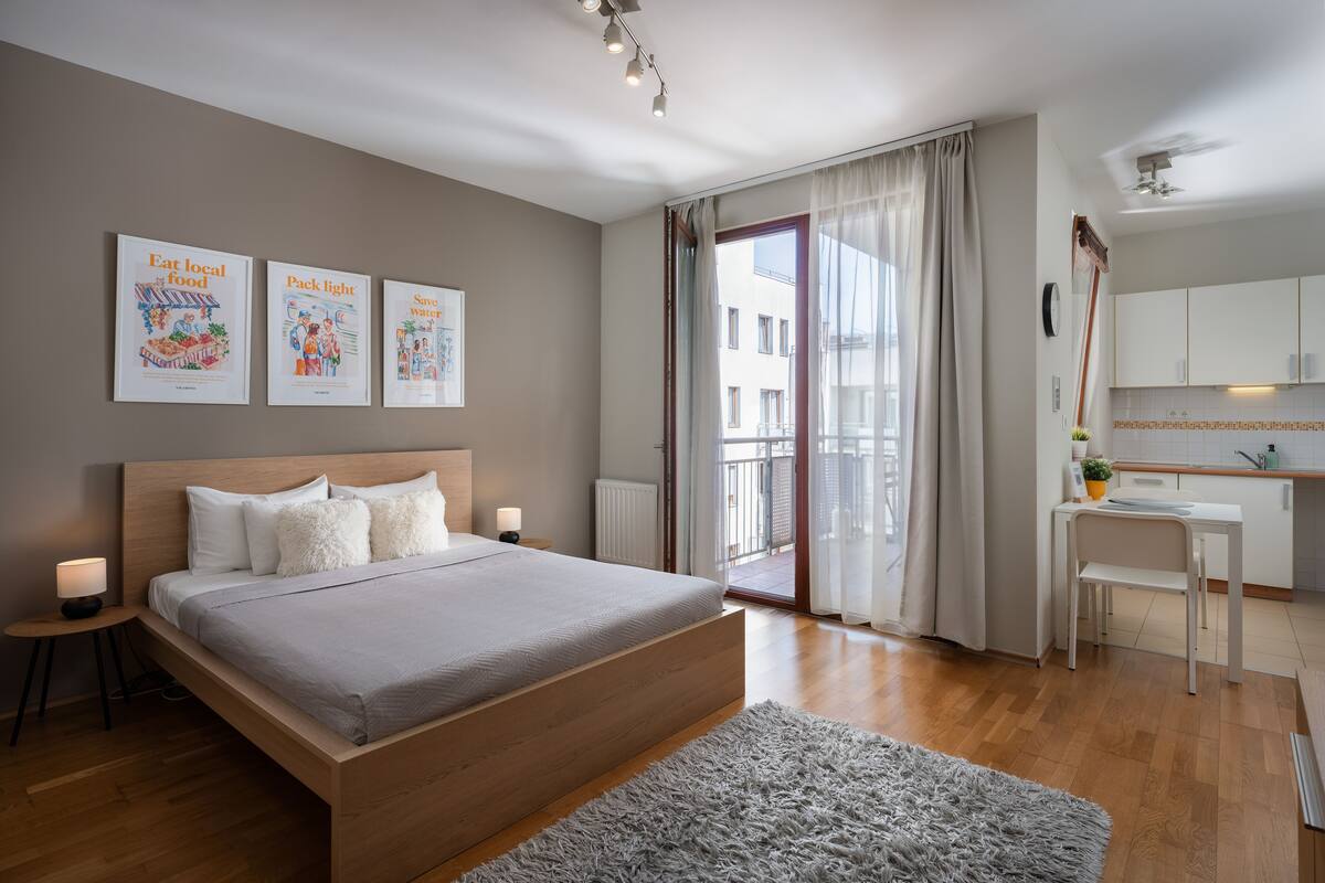 Une chambre moderne avec un grand lit, un bureau et une vue sur l’extérieur.