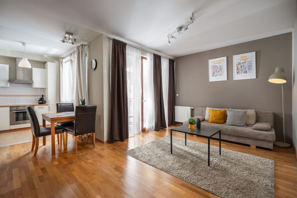 Un salon moderne avec un canapé, une table basse et un coin repas avec des chaises.