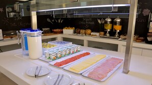 Una mesa de buffet con diversos alimentos y salsas.
