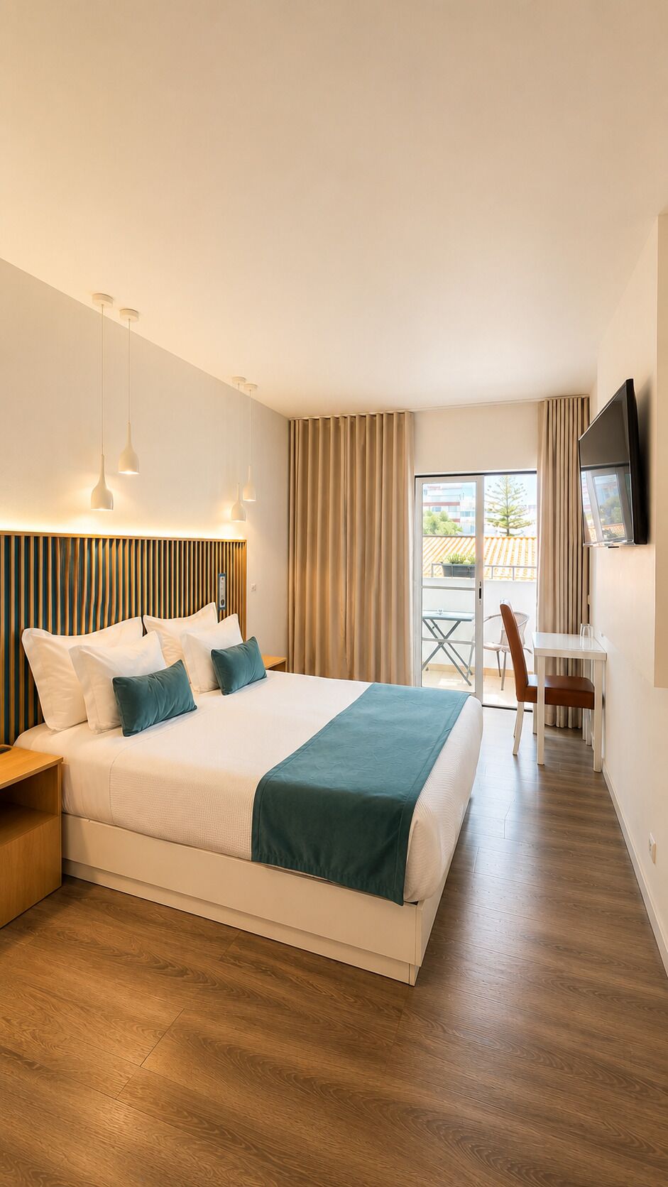 Habitación de hotel con una cama grande, un escritorio, una silla, un televisor y vistas al exterior.
