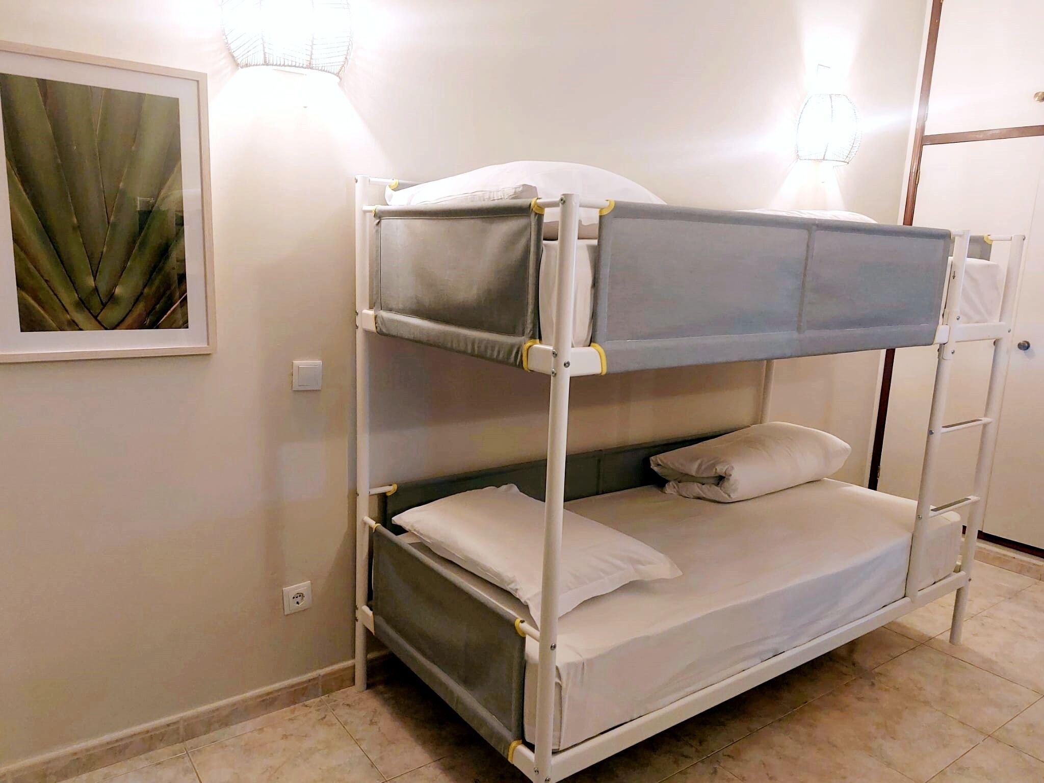 A bunk bed with a headboard, a pillow, and a blanket.