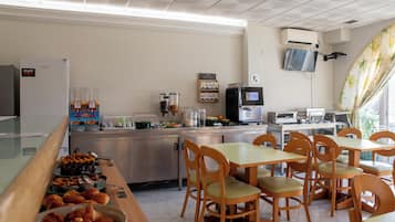 Un espace buffet pour le petit-déjeuner proposant une variété d’aliments, un coin café et des tables où s’asseoir.