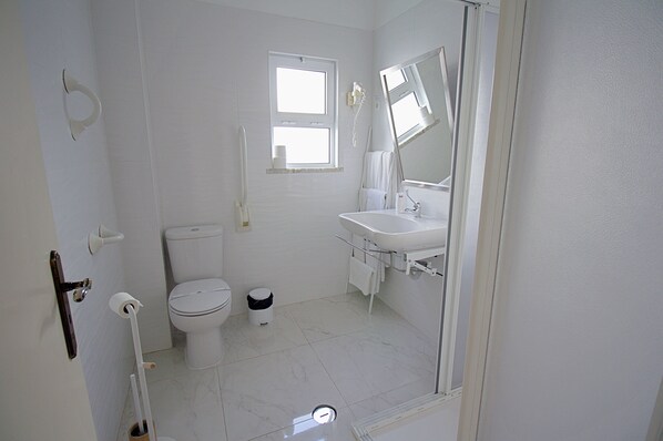 Un baño con inodoro, lavamanos y ventana.