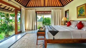 A bedroom with a large bed, wooden ceiling, and a view of greenery outside. - Villa Kaba Kaba Resort Bali (Cepaka)