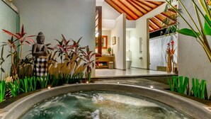 A spa area with a hot tub, indoor plants, and a statue. - Villa Kaba Kaba Resort Bali (Cepaka)