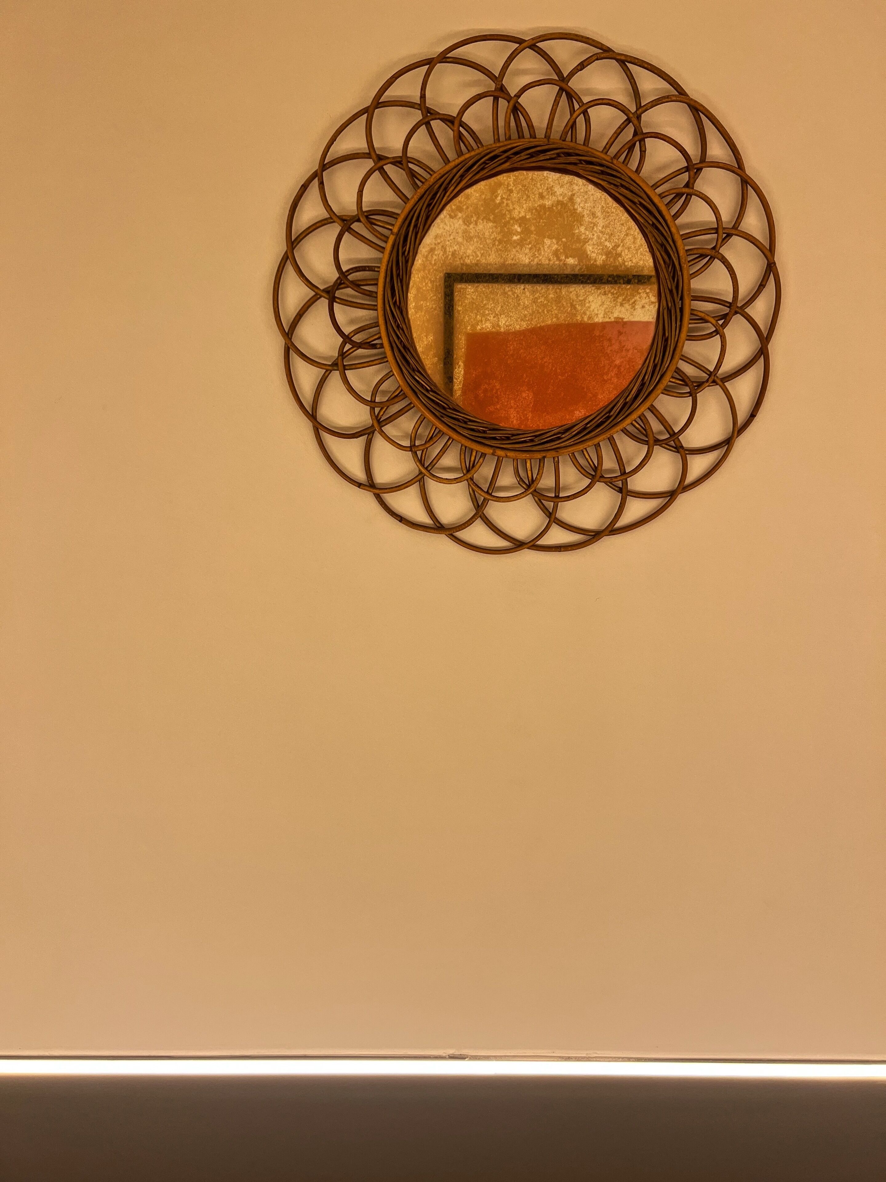 A wall-mounted mirror with a circular frame.