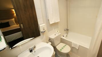 Un baño con lavamanos, inodoro y bañera.