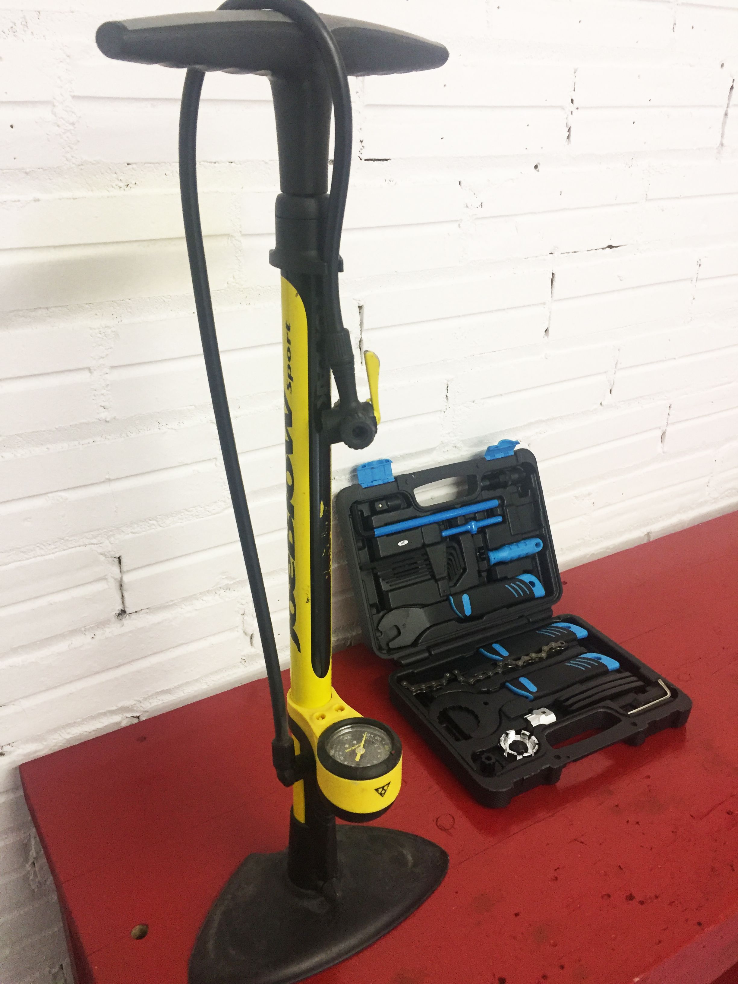A yellow and black electric scooter with a tool case containing blue tools.