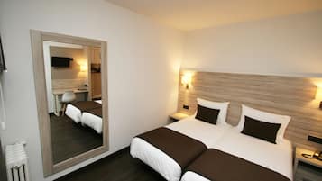 A double bed with a wooden headboard, a large mirror, bedside lamps, and a desk with a chair.