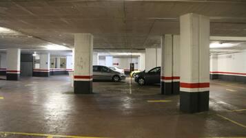 A multi-level parking garage with concrete pillars and yellow parking lines.