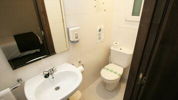 Un baño pequeño con lavamanos, inodoro y espejo.
