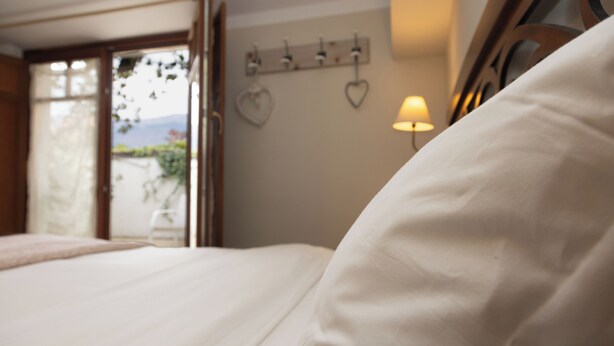 Un dormitorio con una cama, un adorno en forma de corazón en la pared y una lámpara.