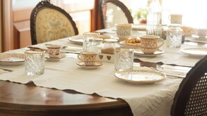 Una mesa de comedor dispuesta con platos, tazas y una jarra.