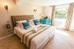 A bedroom with a large bed, a dresser, and a window with curtains. - Le Verger Maelvi (Grimaud)