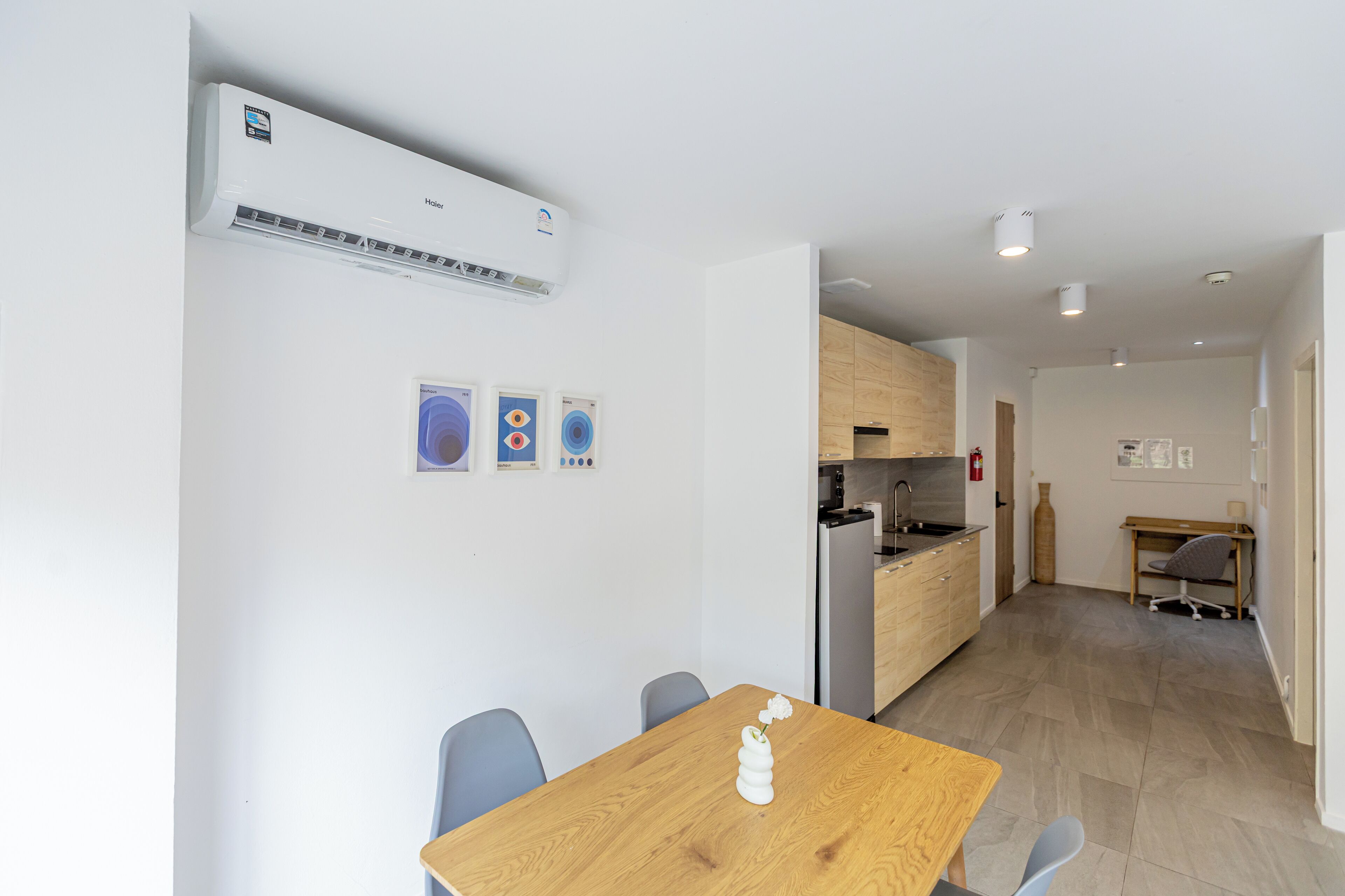 A modern kitchen with a built-in oven and a dining area with a wooden table and chairs.