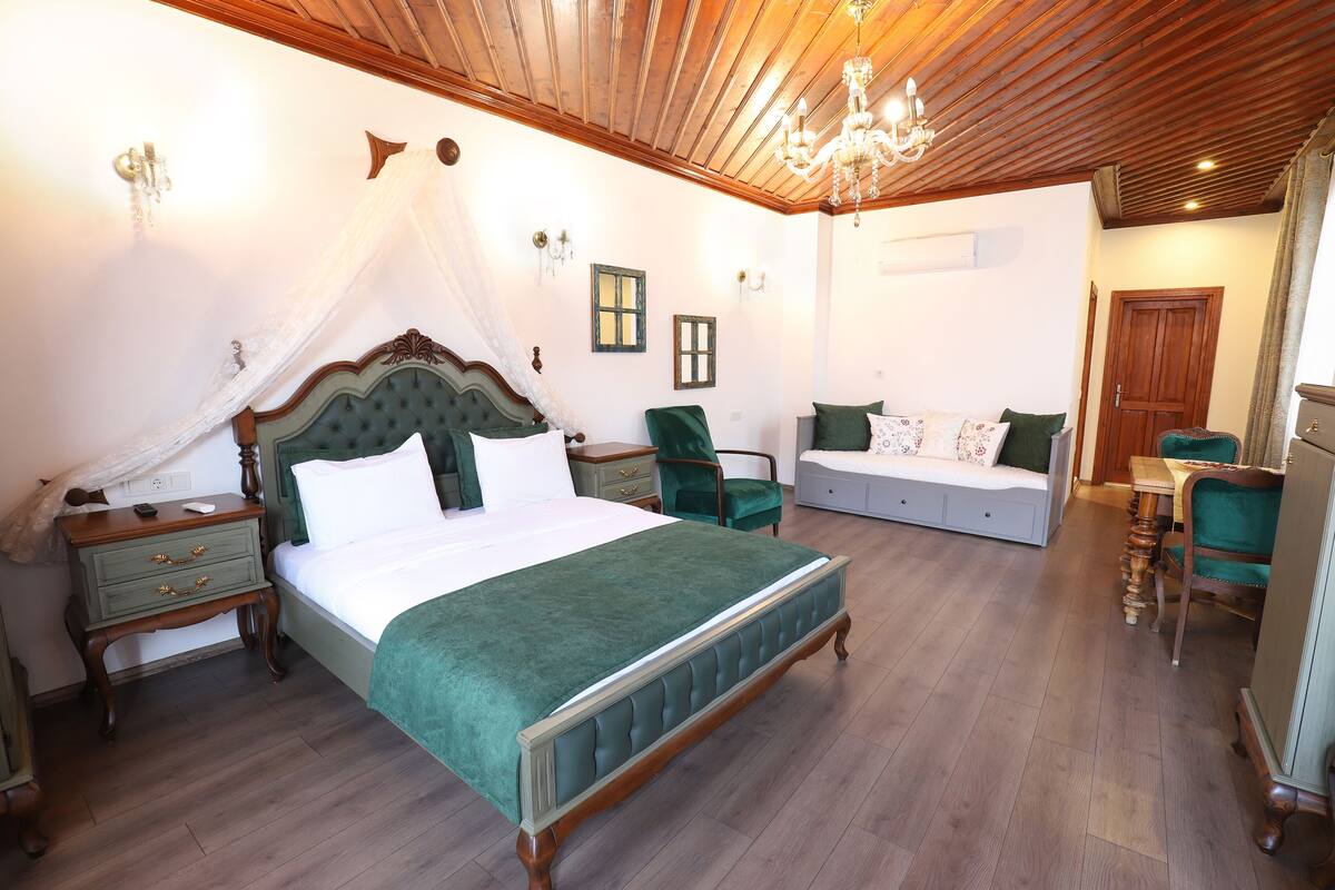 A bedroom with a large bed, a nightstand, a chair, and a dresser.