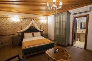 A bedroom with a four-poster bed, a wooden ceiling, a green wardrobe, and a wooden floor.