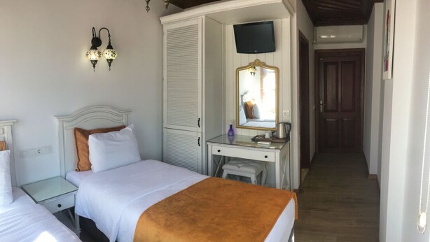 Un dormitorio con dos camas, un escritorio, un espejo y un televisor.