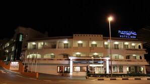 Un hotel de varios pisos con un letrero llamativo que dice "Puertomar Hotel".