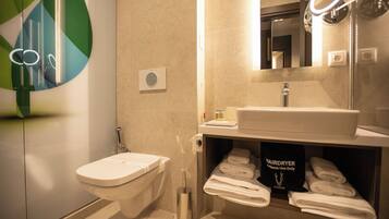 A modern bathroom with a toilet, sink, and towel rack.