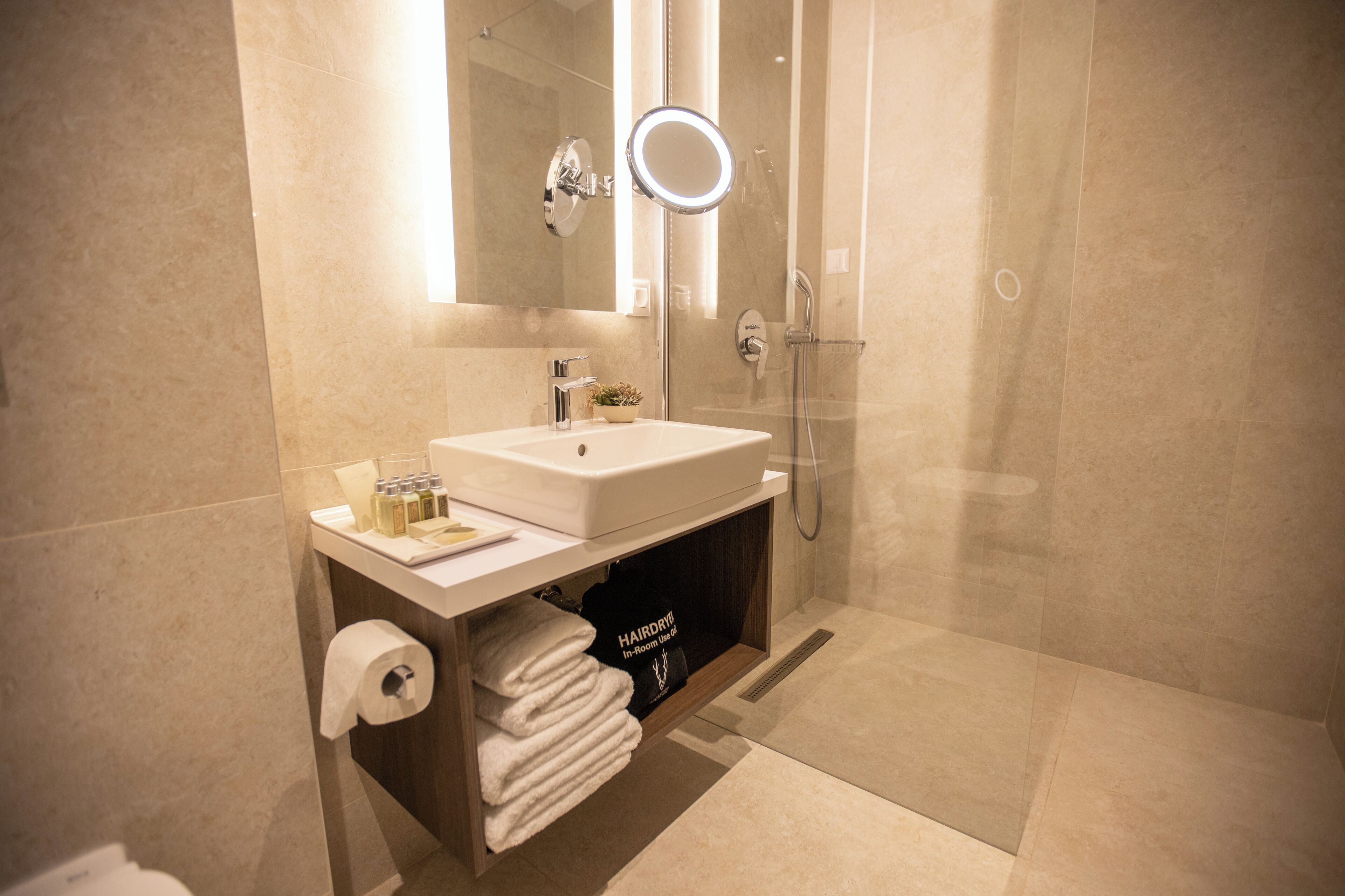 Un bagno moderno con lavandino, specchio e doccia.