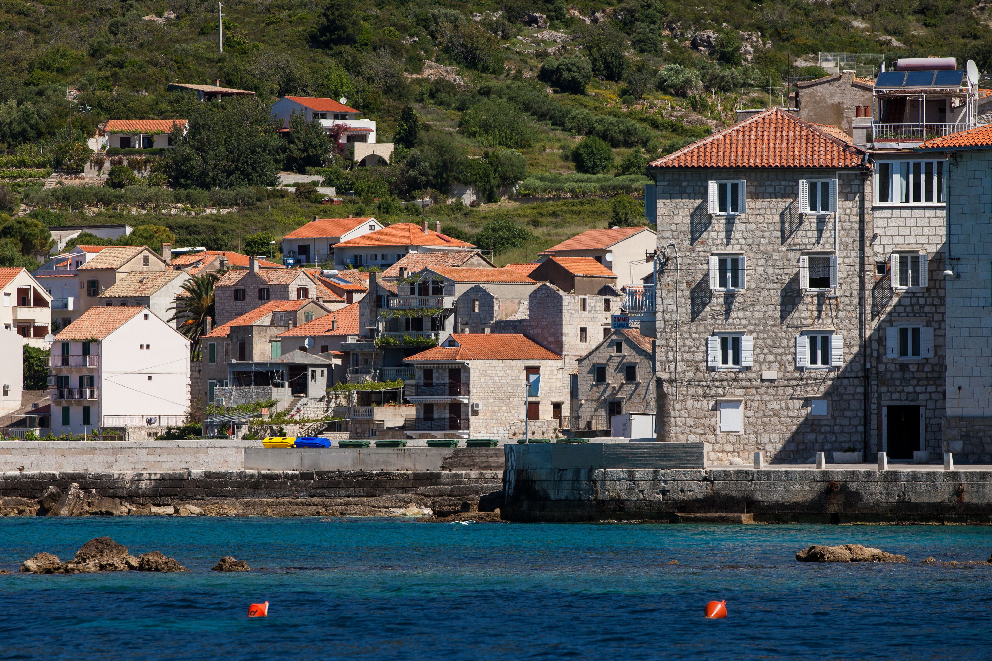 Un pueblo costero con edificios de piedra, vistas al mar y un litoral rocoso.