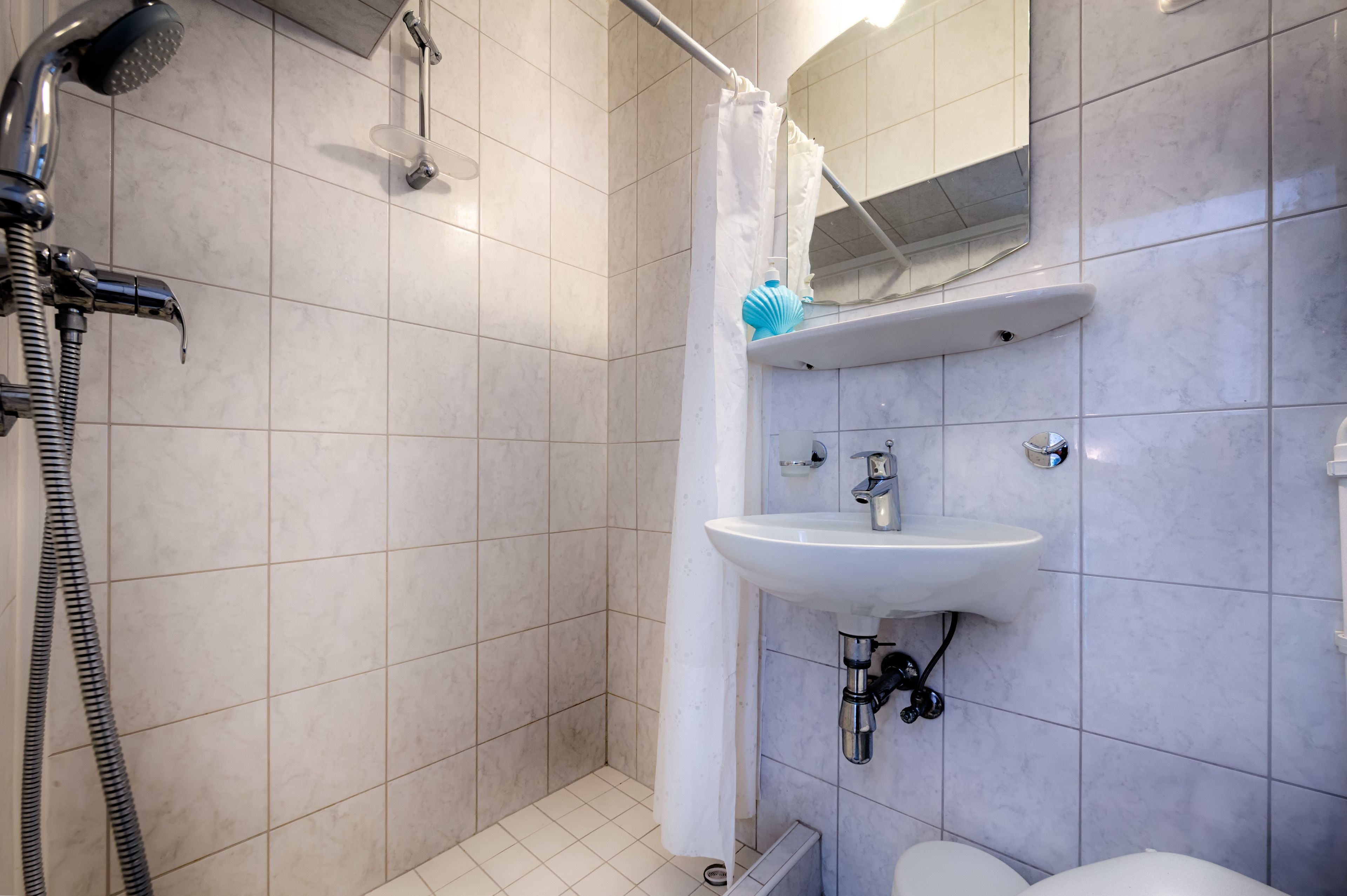 A bathroom with a shower, sink, and toilet.