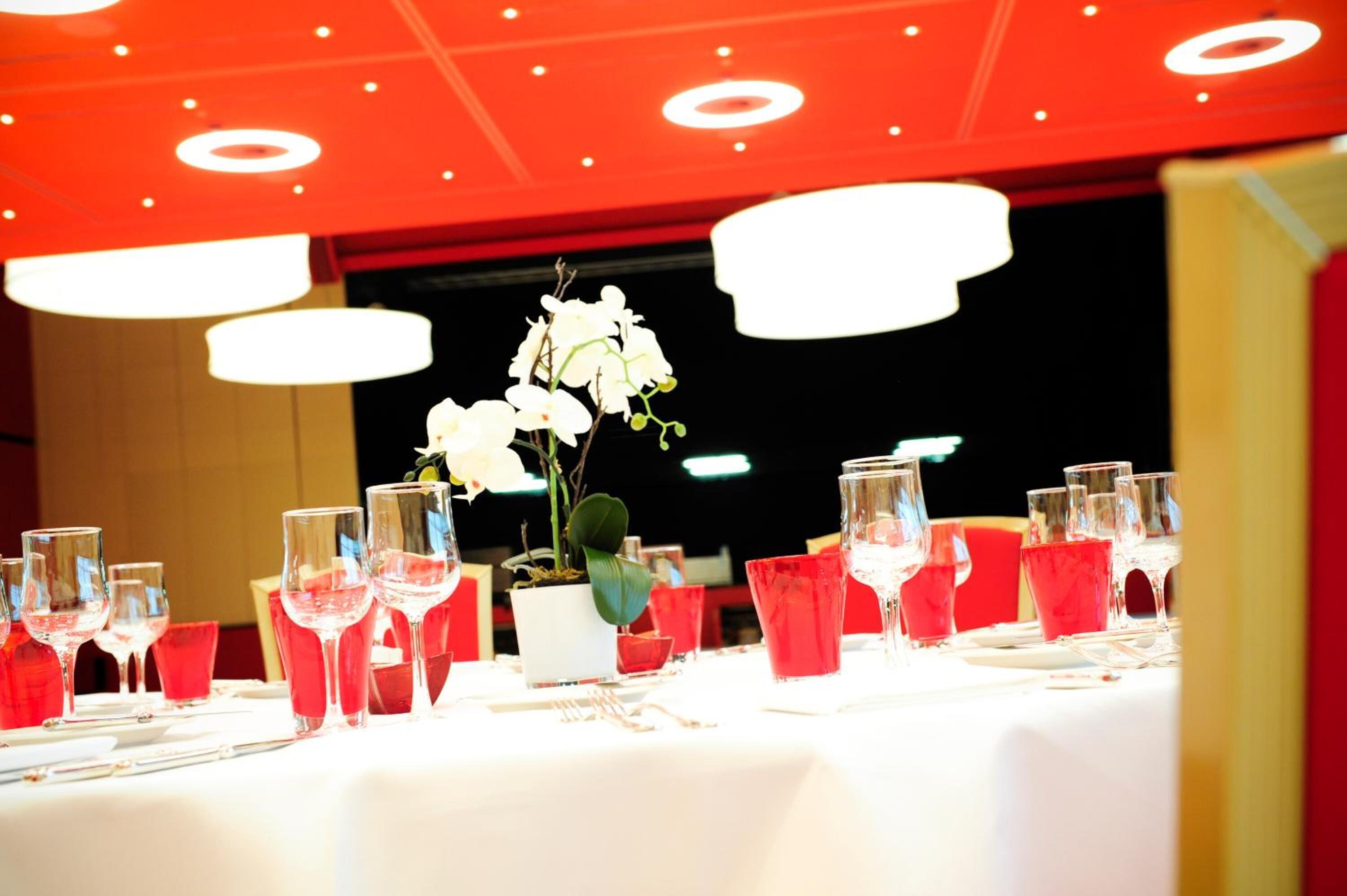 A table set for dining with multiple wine glasses and red napkins.