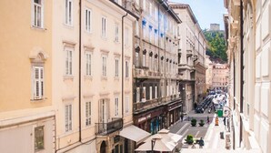 A narrow street with buildings on both sides, a paved walkway, and outdoor seating areas. - Hotel Centrale Trieste (Trieste)