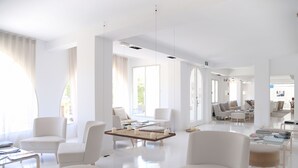 A spacious, modern hotel lobby with white furniture, large windows, and a central coffee table. - Zhero Hotel Mallorca (Calvia)