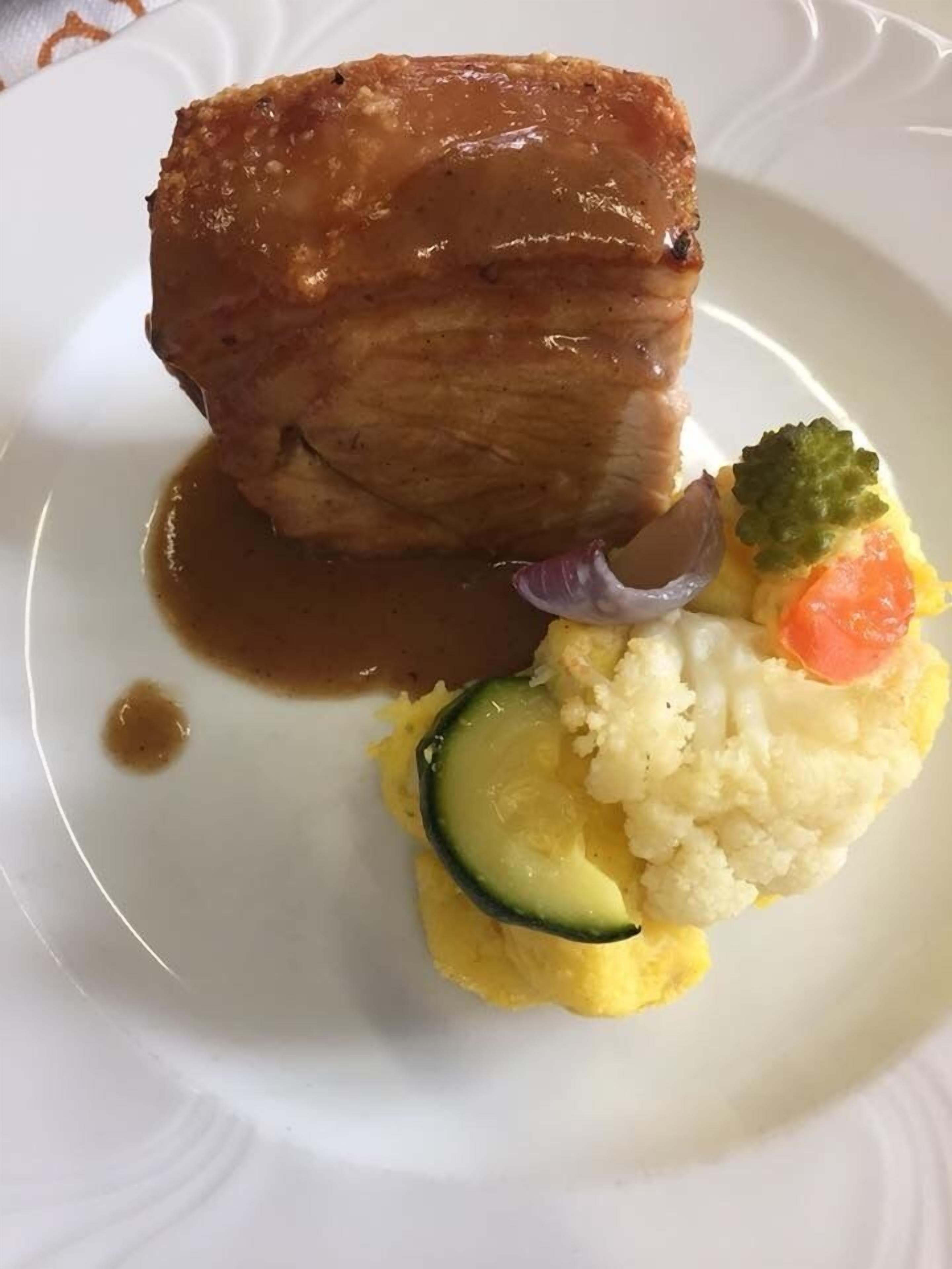 A plate with a piece of meat, mashed potatoes, and vegetables.
