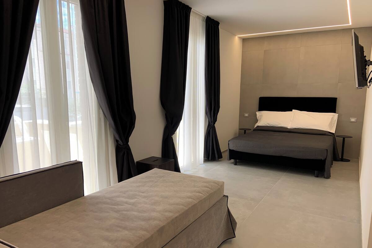 Kamar Triple Junior, pemandangan laut terbatas | Minibar, brankas, meja kerja, dan tirai kedap cahaya