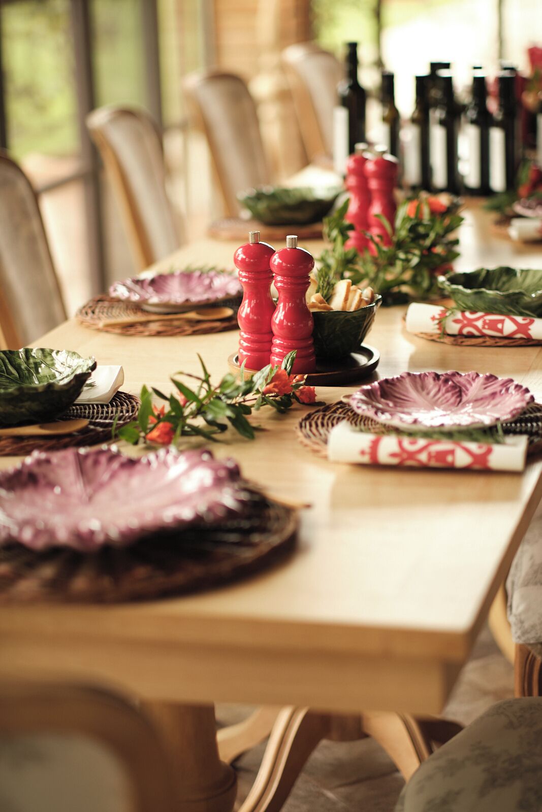 Una mesa de comedor dispuesta con platos, tazones y adornos.