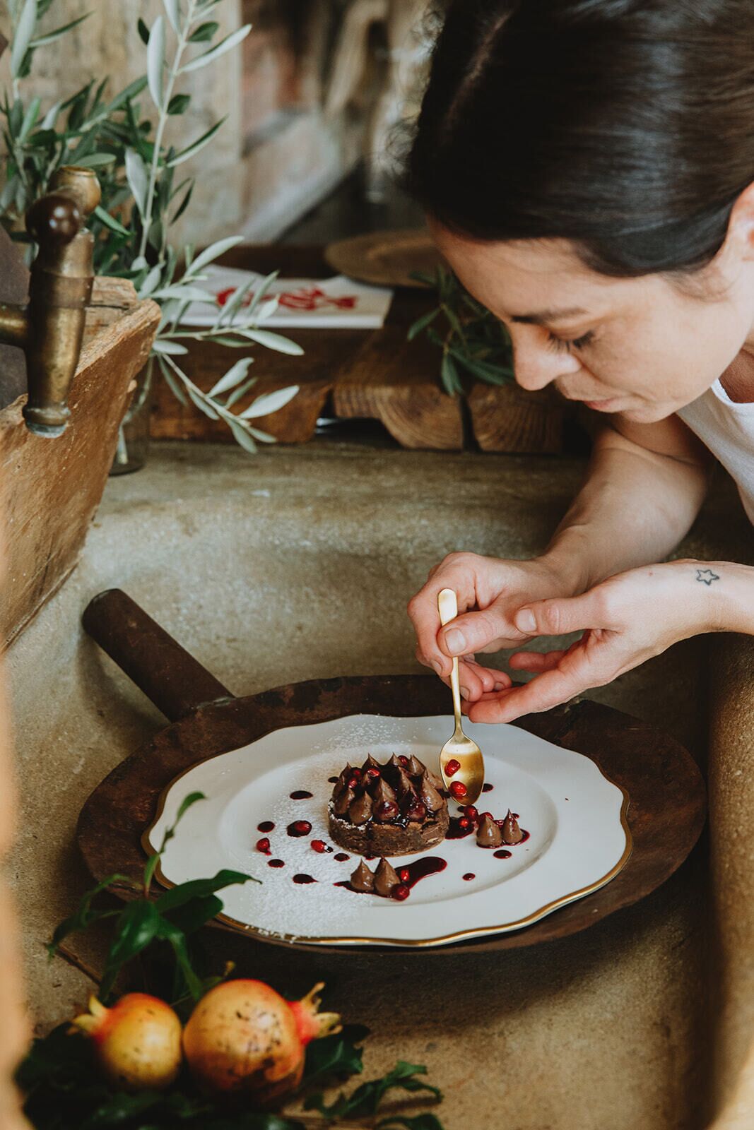 A person serving a dessert on a white plate with a spoon.