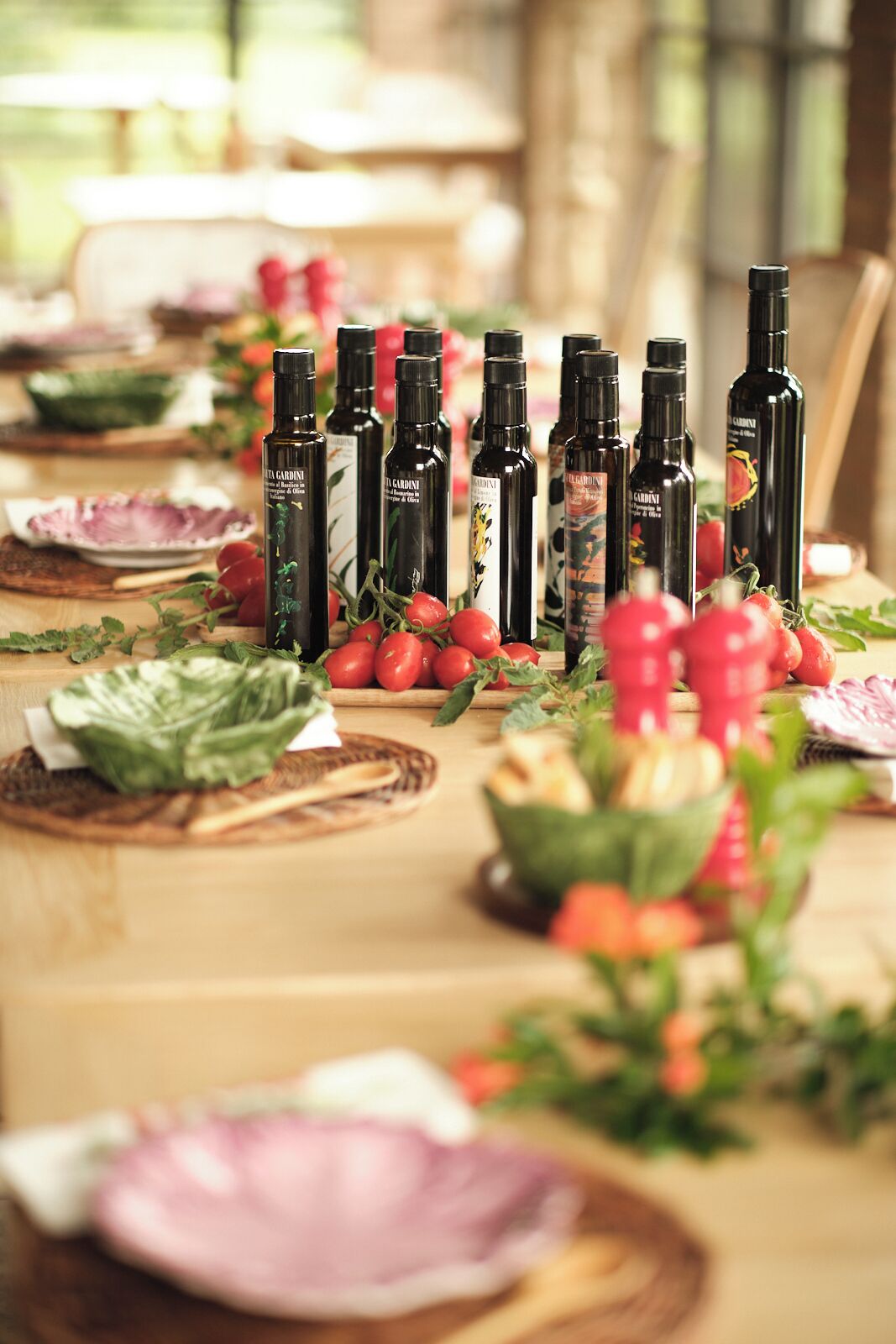A table set with food and drinks, surrounded by bottles of olive oil.