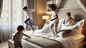 Una habitación de hotel con una cama grande, una mesita de noche con lámpara y una ventana con cortinas.