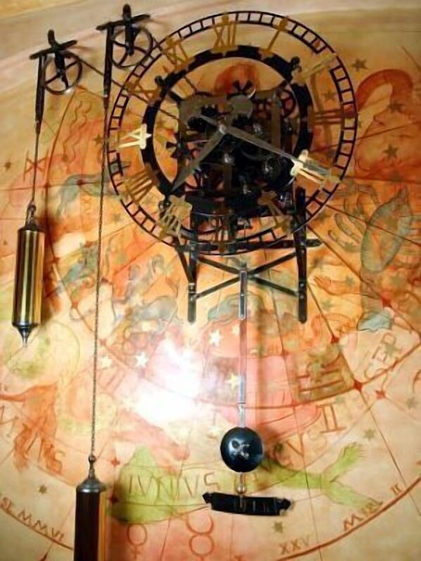 A mechanical astronomical clock with a map backdrop.