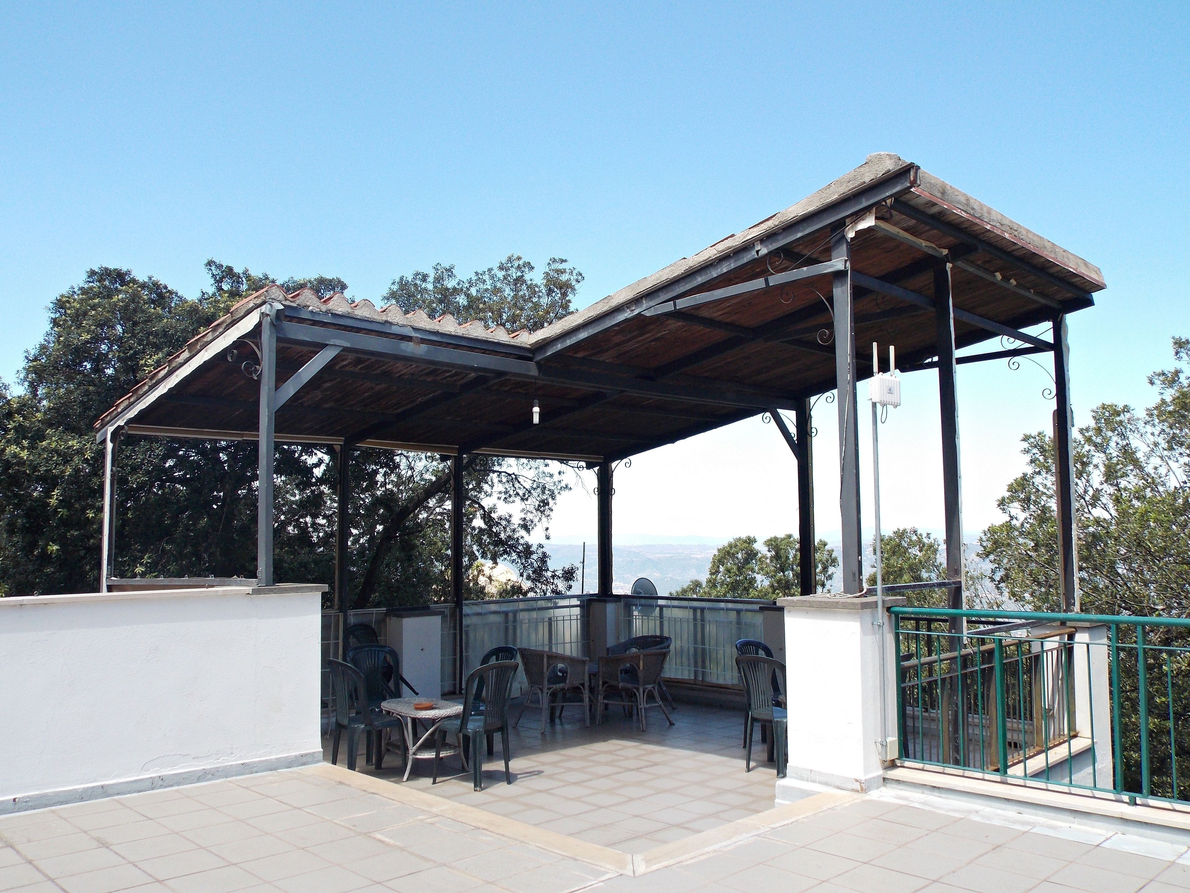 Un espacio de estar al aire libre techado, con vistas al paisaje.
