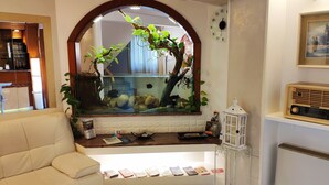 Quarto com aquário, relógio, quadro emoldurado e rádio.