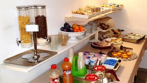 Disposição de buffet com diversos alimentos e bebidas.