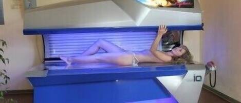 A tanning bed with a person lying on it.