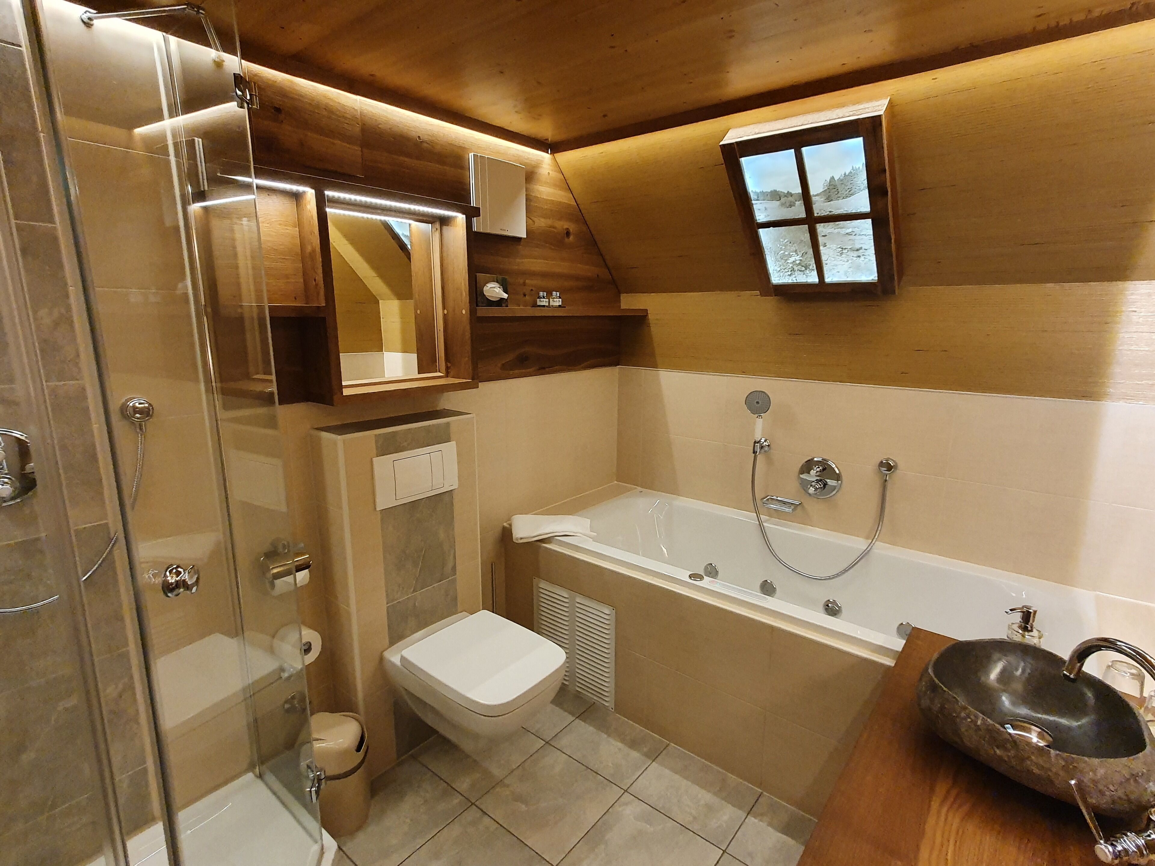 Ein Badezimmer mit Duschkabine, Toilette, Badewanne und einem Holzwaschtisch mit Waschbecken.