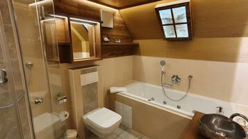 Ein Badezimmer mit Duschkabine, Toilette, Badewanne und einem Holzwaschtisch mit Waschbecken.