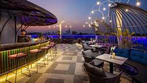 An outdoor bar area with seating and a city skyline view. - Aira Boutique Hanoi Hotel & Spa (Hanoi)