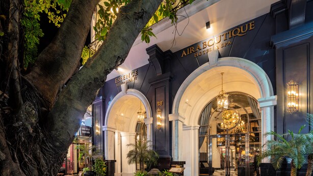A hotel entrance with an arched facade, a sign for 'Air Boutique Hotel & Spa', and a 'Coco Jelly' shop visible in the background. - Aira Boutique Hanoi Hotel & Spa (Hanoi)
