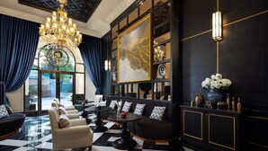 A luxurious lobby with a black and white checkered floor, a grand chandelier, and a seating area with sofas and armchairs. - Aira Boutique Hanoi Hotel & Spa (Hanoi)