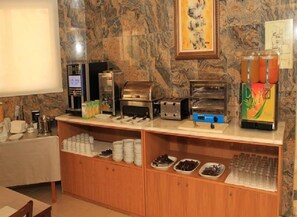 Disposición de bufé con máquina de café, tostadora y dispensador de zumo.