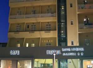 Un edificio de varios pisos con cafetería y señalización de hotel.