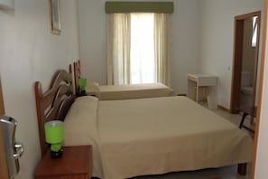 A hotel room with two beds, a bedside table with a lamp, a small desk, and a mirror. - Hotel Santa Catarina Algarve (Portimão)